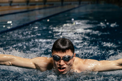 Portrait of young man swimming in pool