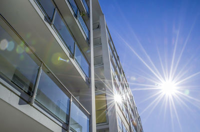 Low angle view of illuminated modern building against clear blue sky