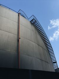 Low angle view of staircase on silo against sky