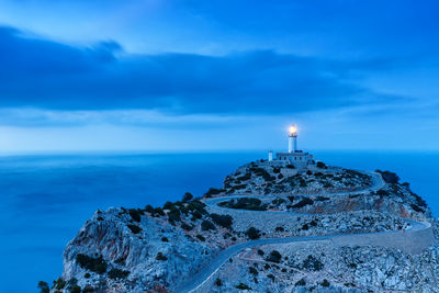 Lighthouse by sea against sky