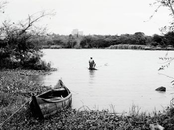 Boat moored in river against sky