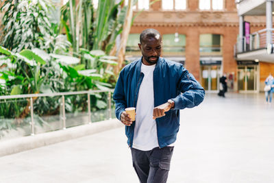 Man checking time while walking outdoors