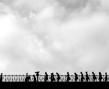 Silhouette people standing against sky