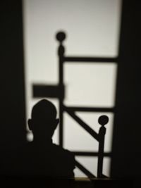 Silhouette man standing by wall in building