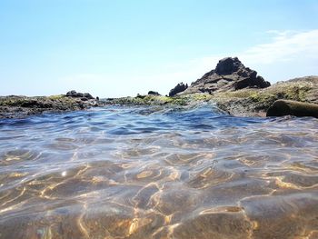 Rocks on beach against clear sky