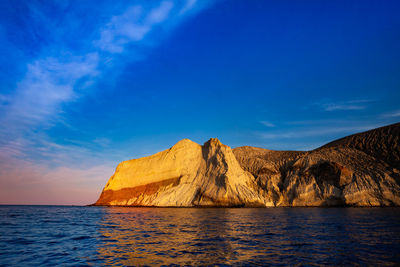 Scenic view of sea and mountains against blue sky