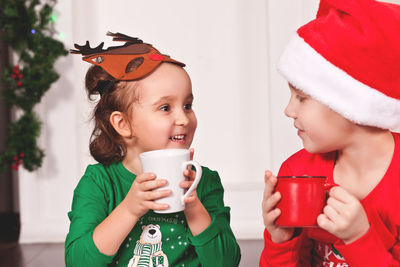 Cute siblings drinking hot chocolate at home