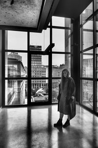 Rear view of woman standing by window