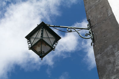 Low angle view of gas light on pole against sky