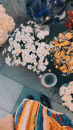 Low section of woman with flowers on table