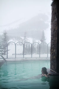 Woman relaxing in swimming pool at ski resort