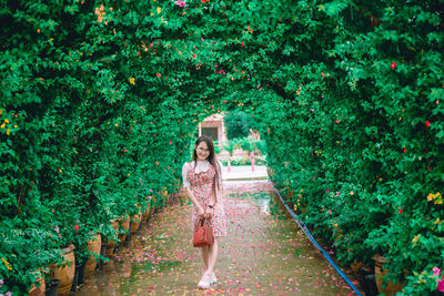 Portrait of woman standing by plants