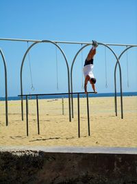 Woman at beach against clear sky
