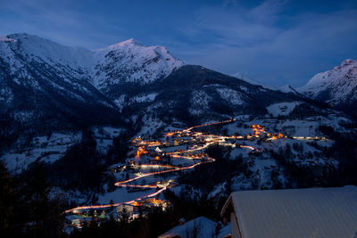 Aerial view of buildings and mountains against sky during winter