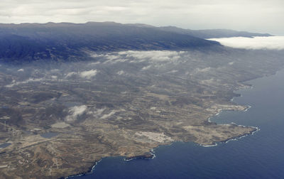 Aerial view of sea and mountains against sky