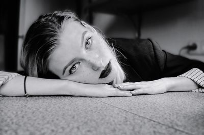 Portrait of young woman lying on bed at home