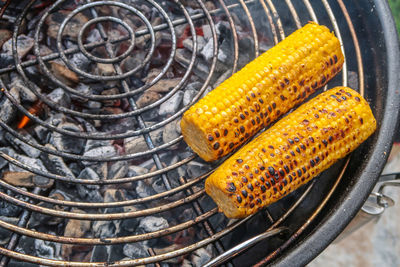 High angle view of corns on barbecue grill