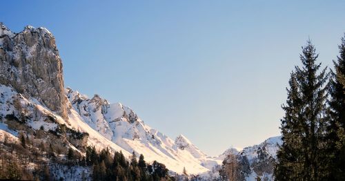 Low angle view of snowcapped mountains against clear sky