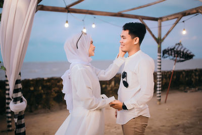 Man and woman standing by building