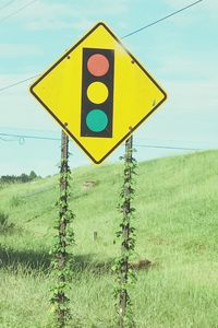 Close-up of yellow arrow sign on field