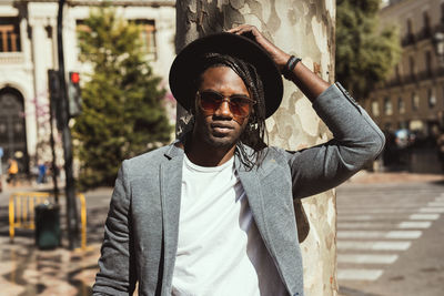 Portrait of young man in hat at city