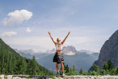 Woman with arms raised overlooking the mountains