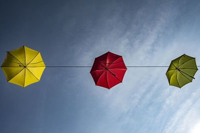 Directly below view of umbrellas hanging against sky