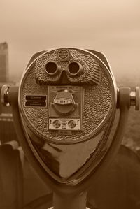 Close-up of coin-operated binoculars against sky