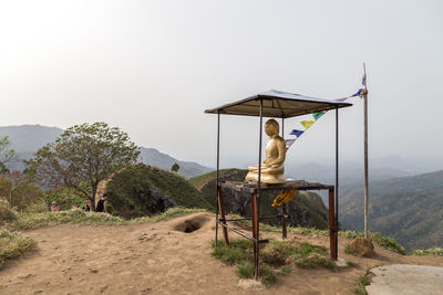 Built structure on land by mountains against clear sky