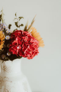 Close-up of pink flower vase against white background