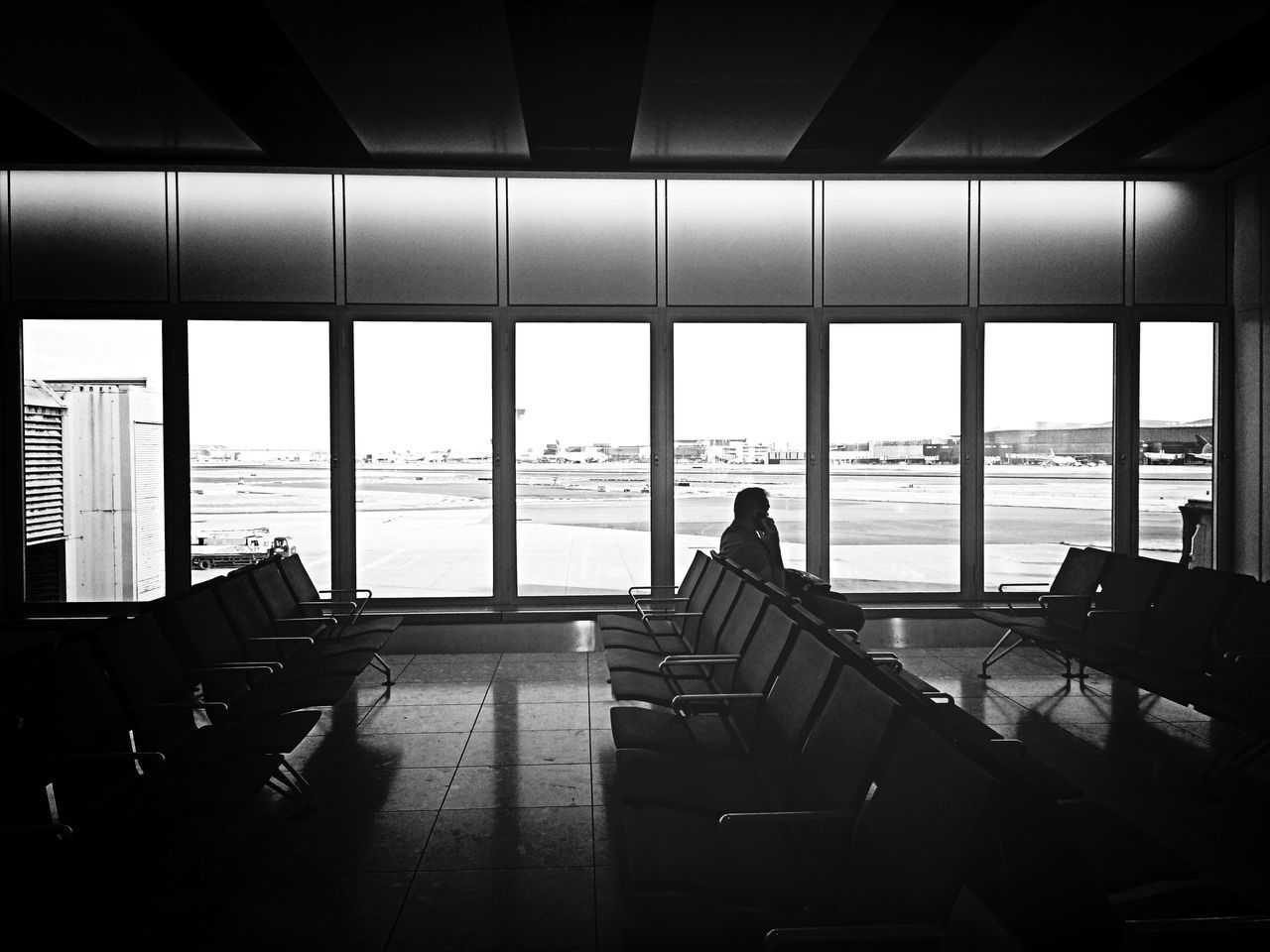 indoors, window, men, sea, silhouette, lifestyles, chair, glass - material, built structure, architecture, person, horizon over water, airport, sitting, leisure activity, restaurant, water, sky, table