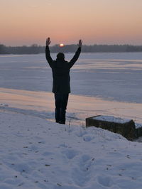 Rear view of man on beach at sunset