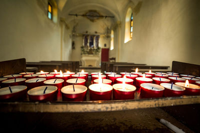 Close-up of candle burning in church