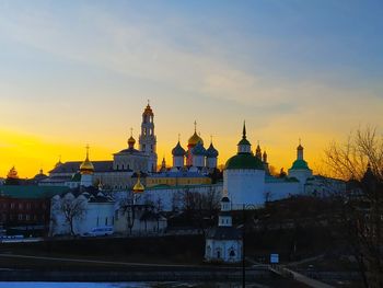 Buildings in city against sky during sunset