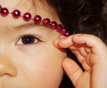 Cropped image of girl wearing beads on head