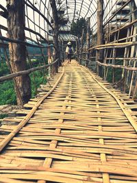 Rear view of man walking on footbridge