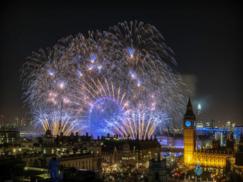 Low angle view of firework display at night