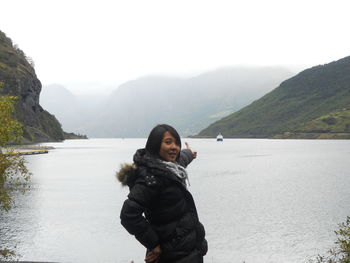 Portrait of woman standing against lake