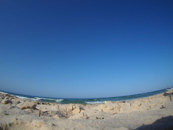 Scenic view of beach against clear blue sky