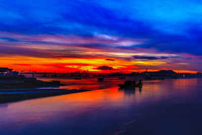 Scenic view of sea against dramatic sky during sunset