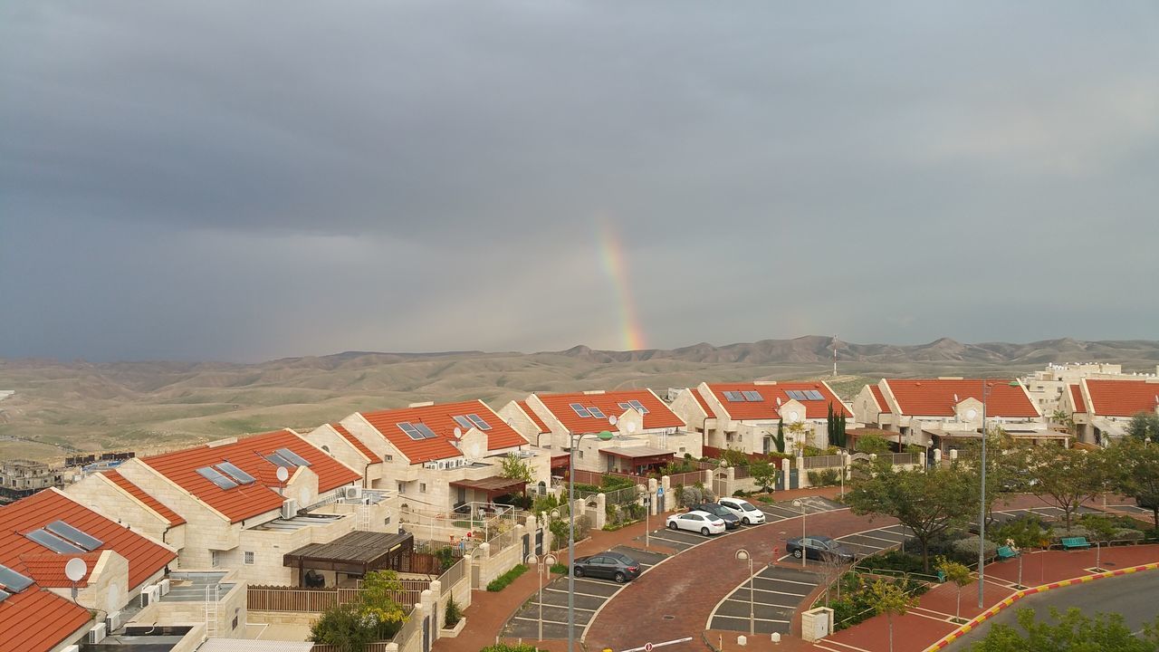 building exterior, architecture, built structure, rainbow, sky, house, residential building, residential structure, cloud - sky, city, residential district, cloudy, weather, high angle view, roof, overcast, storm cloud, town, street, outdoors