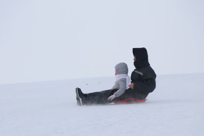 Rear view of two people on snow covered land