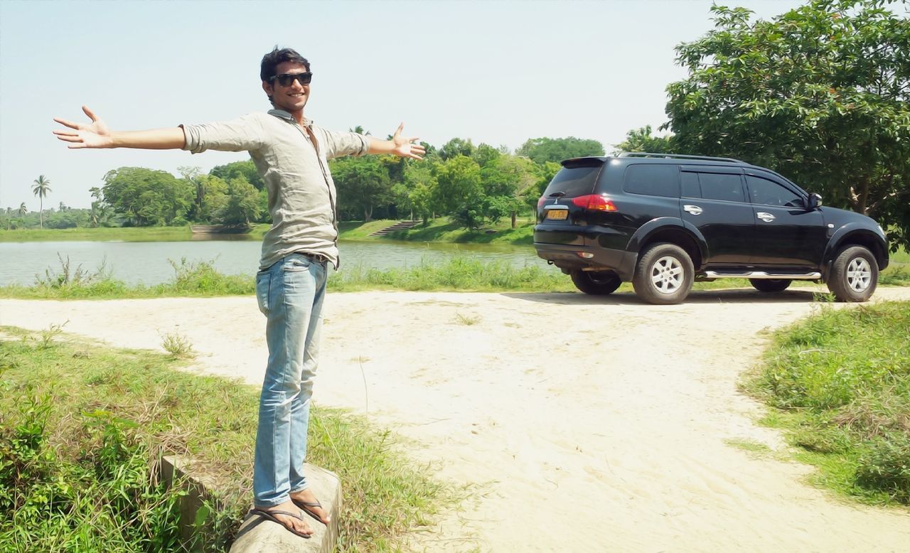 lifestyles, young adult, leisure activity, full length, casual clothing, person, grass, young men, tree, jumping, side view, sunlight, front view, standing, mid-air, field, holding