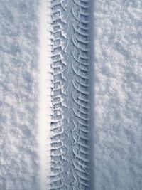 Close-up of tire track on snow covered field