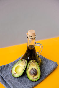 Pitcher of natural oil and fresh ripe hass avocados. preparing food in the kitchen. ingredients. 