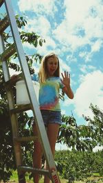 Portrait of young woman standing against the sky