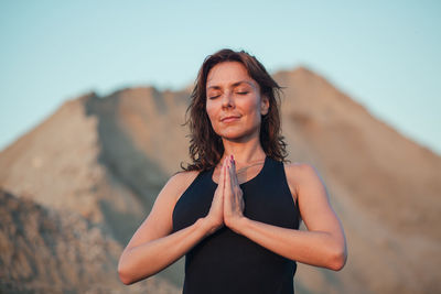 Portrait of woman standing against sky