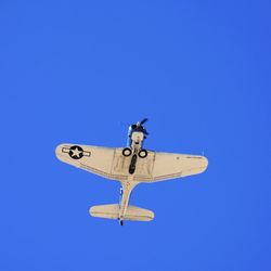 Low angle view of airplane against clear blue sky