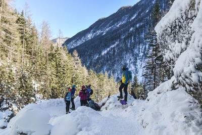 People on snow covered mountain against sky