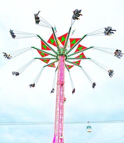 Low angle view of chain swing ride against sky